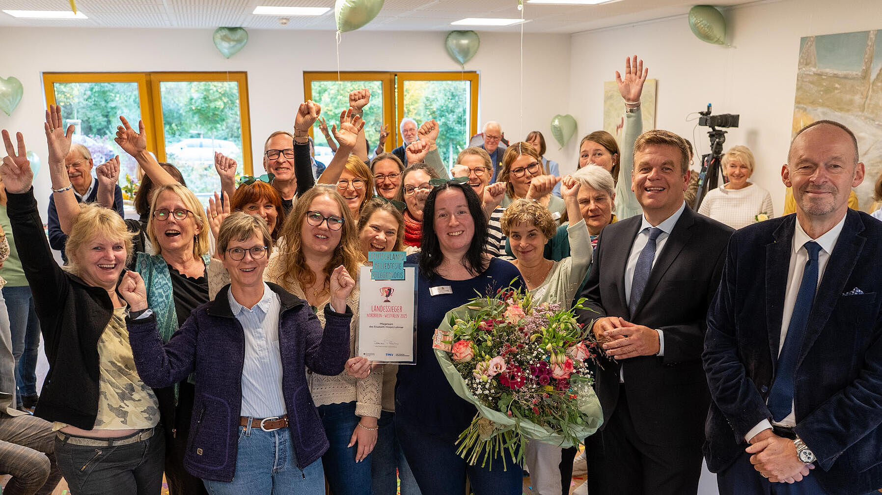Das Pflegeteam des Elisabeth-Hospizes Lohmar jubelt nach der Preisverleihung gemeinsam mit Matthias Heidmeier, Staatssekretär im Ministerium für Arbeit, Gesundheit und Soziales (2.v.r.) und PKV-Geschäftsführer Joachim Patt (1.v.r.).